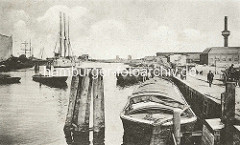 Historische Ansicht aus dem Harburger Hafen - Binnenschiffe liegen am Kai, ein Segelschiff liegt in der Mitte des Hafenbeckens. (ca. 1910)