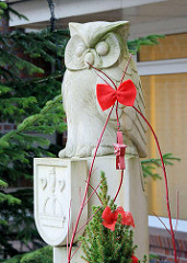 Skulptur Eule mit Quickborner Wappen, Weihnachtsdekoration mit roter Schleife.