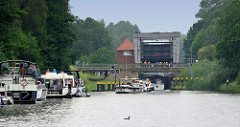 Schleuse in Mirow - Teil der Müritz Havel Wasserstrasse; technisches Denkmal / Höhenunterschied von 3,50m. Sportboote warten am Ufer - andere fahren in die Schleusenkammer ein - grünes Signallicht.