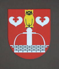 Quickborner Wappen - Brunnen mit goldener Eule, zwei silberne Seeblätter.