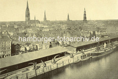 Luftaufnahme vom Sandtorhafen / Sandtorkai, und Brooktorviertel im historischen Hamburg - Wohnhäuser hinter den Kaischuppen am Sandtorkai, Frachter und Schuten  liegen am Kai. Kirchtürme der Hansestadt Hamburg. ( ca. 1870 )