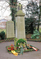 Gedenkstätte beider Weltkriege im Quickborner Ortsteil Renzel, Friedenstrasse. Stele mit Adler und Inschrift, Kränze.