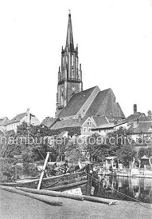 Ufer vom Hafen in Rathenow, Bug eines Binnenschiffs / Lastkahn - Gartenlauben am Havelufer; St. Marien Andrea Kirche zwischen Hausdächern der Stadt.