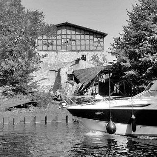 Ruine der Steinhavelmühle an der Steinhavel in Fürstenberg ( Havel) - Bug eines fahrenden Sportboots.