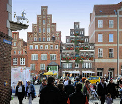 Blick aus der Kleinen Bäckerstrasse auf den Lüneburger Platz Am Sande - historische Giebelhäuser, Passanten.
