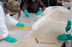 Laminieren beim Bootsbau - Epoxidharz wird auf der aufgebrachten Glasfasermatte mit dem Spachtel verteilt und angedrückt.