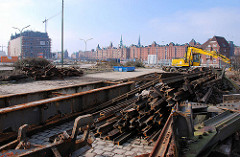 Eisenteile, alte Eisenbahnschienen der Hamburger Hafenbahn - im Hintergrund Blick über den Ericusgraben zur Speicherstadt Hamburgs.