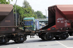 Ein Güterzug mit Schuttgut-Waggons überquert die Versmannstrasse in dem Hamburger Stadtteil Hafencity - Lastwagen müssen warten.