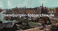 Panorama vom Sandtorhafen und der Speicherstadt Hamburg - die Lagerschuppen liegen direkt am Sandtorkai und schützen mit ihren breiten Dächern die Ware die auf die Schiffe am Kai verladen werden. Im Vordergrund transportieren Pferd und Wagen Ware