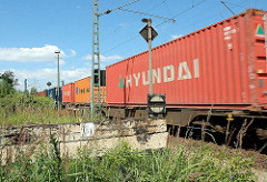 Containernzug in Hamburg Wilhelmsburg - im Vordergrund ein alter Holz Prellbock.