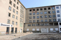 Planung zur Sanierung eines Gebäudeteils in Prora an der Ostsee - Hinweisschild zum Showroom einer vorbereiteten Eigentumswohnung in dem Gebäude.