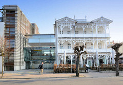 Neu + alt; weisse Bädervilla mit Holzschnitzerein am Balkon - moderner Neubau mit verglaster Verbindung.