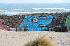 Graffiti an der verwitterten Betonmauer am Strand von Prora / Binz an der Ostsee; geplante Promenade am Wasser.