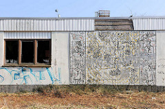 Fassadenrelief der Errungenschaften durch die sozialistische Gesellschaft an einem verlassenen Gebäude in Prora / Binz auf Rügen.