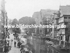 Blick über den historischen Holländischen Brook ca. 1880; dicht gedrängt stehen die Fachwerkhäuser und Lagerhäuser am Fleet. Schuten u.a. mit Kohle beladen liegen am Kai, ein Pferdewagen steht auf dem Kopfsteinpflaster.