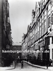Blick in den neuen Wandrahm kurz bevor die Abrissarbeiten für den Bau der Hamburger Speicherstadt beginnen. Die Häuser haben prächtig dekorierte Barock - Fassaden, ein Pferdewagen transportiert Waren über das Kopfsteinpflaster.