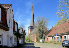 Wohnhäuser; Kirchturm und Kirchenschiff der Immanuelkirche in Wedel.