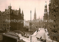Blick über den Kannengiesserort in der Speicherstadt Hamburg - Pferdefuhrwerke fahren in den Pickhuben ein. Links der 1888 erbaute Speicherblock H, rechts ein Ausschnitt vom Lagerhaus Q.