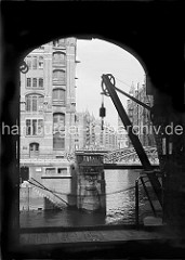 Blick vom Speichergebäude H auf die Kannengiesser- ortbrücke und die dahinter liegenden Speicher am Wandrahmsfleet. Mit dem Wandkran konnte die Ware vom Lagerboden auf die Schiffe geladen werden.