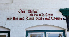 Inschrift am historischen Gebäude, Marktplatz von Wedel: Gott schütze dieses alte Haus vor Not und Feuer Krieg und Steuer.
