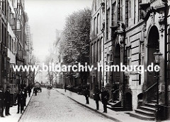 Blick in den alten Wandrahm kurz bevor die Abrissarbeiten für den Bau der Hamburger Speicherstadt beginnen. Die Häuser haben prächtig dekorierte Barock - Eingänge, Strassenlaternen sind an der Hausfassade angebracht oder stehen am Strassenrand.