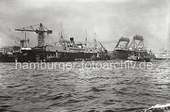 Blick über die Elbe auf die Werftanlagen der DEUTSCHEN WERFT am Reiherstieg - auf den Portal der Kabelkräne steht der Schriftzug der 1918 auf Finkenwerder gegründeten Hamburger Werft.