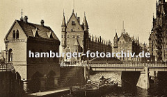 ein Schiff hat gerade die St. Annenbrücke in der Hamburger Speicherstadt passiert - um die niedrige Brückendurchfahrt zu ermöglichen ist der Mast des Schiffes umgelegt.