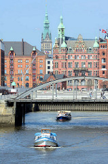 Barkassen der Hamburger Hafenrundfahrt fahren im Magdeburger Hafen - im Hintergrund das Speicherstadt- Rathaus, Sitz der HHLA und der Turm vom Hamburger Rathaus.
