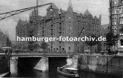 Blick über die St. Annenbrücke zum Speicherblock R - Wagen sind mit Stapeln von Säcken beladen und werden von Pferden gezogen - re. sitzt ein Kutscher auf dem Bock seines leeren Wagens und wartet auf Ladung.