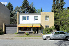 Einelhaus mit Ladengeschäft und Garage - Baustil der 1960er Jahr; gelbe Klinkerfassade - Architektur in Hamburg Stellingen.