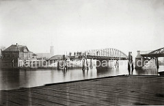 Blick auf die geöffnete Drehbrücke am Niederhafen - Holzdalben schützen die Brückenkonstruktion. Am Ufer ein Fachwerkhaus des Brückenwärters.