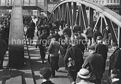 Niederbaumbrücke über den Zollkanal; Hafenarbeiter gehen nach Schichtende nach Hause - im Hintergrund das Gebäude der Hochbahnhaltestelle Baumwall.