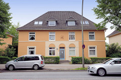 Wohnhaus im Baustil der 1930er Jahre - ockerfarbene Fassade, Strassenverkehr an der Bremer Strasse in Hamburg Eissendorf.