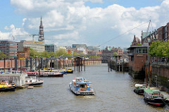 Blick über den Binnenhafen zum Zollkanal - ein Fahrgastschiff fährt in den Kanal ein - lks. die Altstadt Hamburgs, re. Gebäude der Speicherstadt.