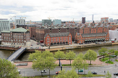 Blick vom Dach des Chilehauses auf die Speicher und Zollgebäude am Zollkanal in der Speicherstadt Hamburgs - im Hintergrund die moderne Architektur der Neubauten des neuen Hamburger Stadtteils Hafencity.