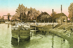 Alte Ansicht an der Elde Schleuse in Dömitz - ein Frachtschiff liegt am Ufer - Kinder spielen an Land; im Hintergrund die Klappbrücke.