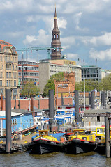 Barkassen und Arbeitsboote im Hamburger Binnenhafen - im Hintergrund die Hohe Brücke und der Kirchturm der St. Katharinenkirche.