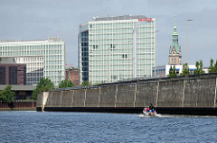 Bürogebäude an der Ericusspitze in der Hamburger Hafencity - Spiegelverlagshaus; daneben der Kupferturm vom Hamburger Rathaus; hohe Kaimauer - Sportboot in Fahrt auf dem Oberhafenkanal.
