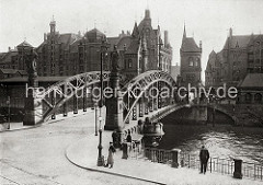 Blick auf die Brooksbrücke über den Zollkanal, der die Grenze zu dem Hamburger Freihafengebiet ist. Auf der Stadtseite der Brücke stehen die Figuren HAMMONIA und EUROPA auf Sockeln - auf der Speicherstadtseite befindet sich in zwei hohen neu