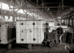 Eine grosse Holzkiste mit der Aufschrift Made in USA wird von einem Lagerarbeiter mit einem Hubwagen der Herstellerfirma YALE an ihrem Platz im Lagerschuppen abgestellt; ca. 1934.