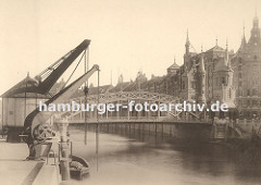 Blick zur Brooksbrücke, die über den Zollkanal zum Hamburger Freihafengelände und der Speicherstadt führt. An den Kaimauern des Kanals an der Strasse "Bei dem Neuen Krahn" stehen zwei Kräne die die Ladung von den Schiffen an Land hieven.