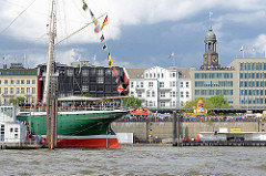 Heck vom Museumsschiff Rickmer Rickmers - Menschenmenge auf der Hafenpromenade; Kuppel vom Michel / Michaeliskirche.