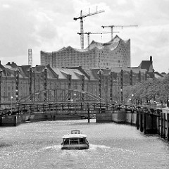 Ein Fahrgastschiff fährt auf dem Zollkanal Richtung Binnenhafen - Skyline der Hamburger Speicherstadt mit Elbphilharmonie.