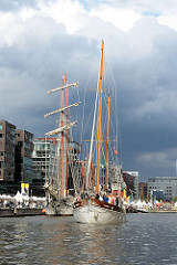 Traditionsschiffhafen in der Hamburger Hafencity - der Großsegler TOLKIEN liegt am Ponton, das Traditionssegelschiff FREDDY, Baujahr 1946,  fährt rückwärts zu seinem Liegeplatz.