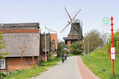 Wohnhäuser und Windmühle / Borsteler Mühle in  Jork, Altes Land - Radfahrer.