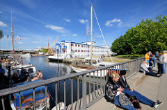 Brücke am Kanalplatz in Hamburg Harburg - Sportboote im Kaufhauskanal, im Hintergrund das Flüchtlingsschiff Transit. Auf dem 110 m langen Schiff können ca. 200 Flüchtlingen Platz finden.