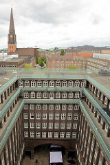 Blick in den Innenhof vom Chilehaus im Hamburger Kontorhausviertel; im Hintergrund die Jakobikirche.