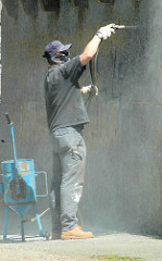 Der Sockel vom Hamburger Bismarckdenkmal ist mit Grafitti beschmiert; ein Arbeiter säubert den Stein mit Druckluft.