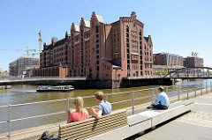 Mittagspause in der Sonne am Störtebekerufer in der Hamburger Hafencity - eine Barkasse fährt durch den Magedeburger Hafen am ehem. Kaispeicher B, jetzt Internationales Maritimes Museum - dahinter Gebäude an der Elbtorpromenade.