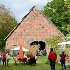 Kulturelle Landpartie im Wendland / Hof in Luckau; Kaffeetrinken unter dem Sonnenschirm, Kunst auf der Tenne einer Fachwerkscheune.